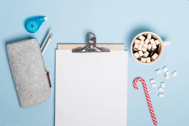 Chocolat chaud avec des guimauves et des bonbons pour ordinateur portable sur une vue de dessus de table bleue Mise à plat de Noël