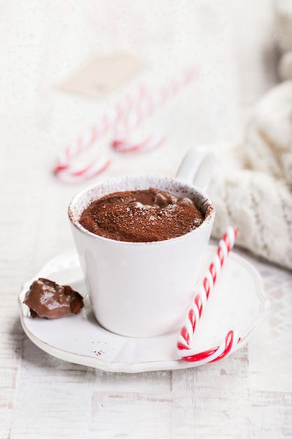 Chocolat chaud de Noël avec du cacao et de la canne à sucre, closeup avec de la neige sur un fond