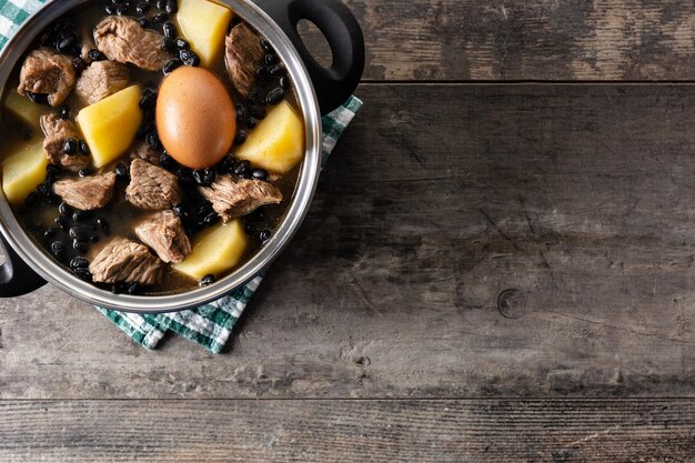 Cholent juif traditionnel en cocotte sur table en bois