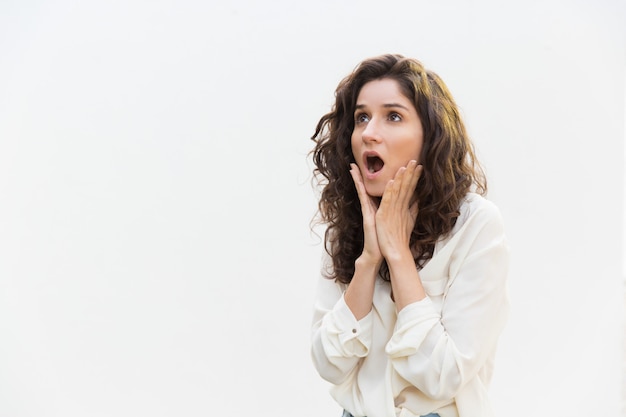 Choqué excité femme haletant, touchant les joues