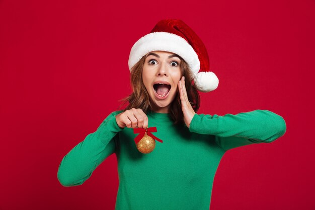 Choqué excité jeune femme portant un bonnet de noel