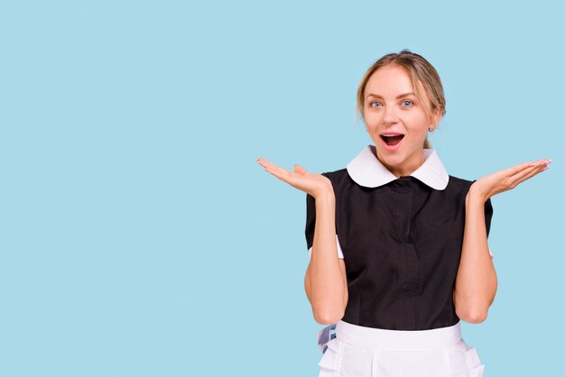 Choqué femme regardant la caméra avec la bouche ouverte sur fond bleu