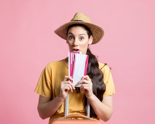 Photo gratuite choqué femme tenant ses billets d'avion