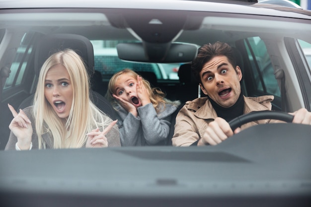 Choqué Homme Assis Dans La Voiture Avec Sa Femme Et Sa Fille