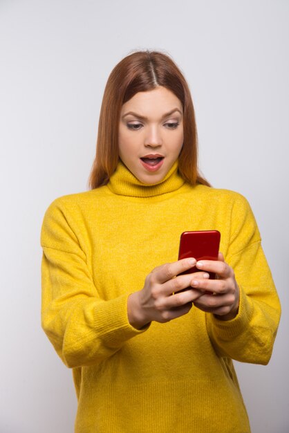 Choqué de jeune femme à l'aide de smartphone