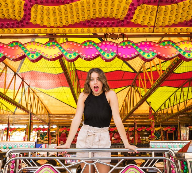 Choqué jeune femme debout au parc d&#39;attractions