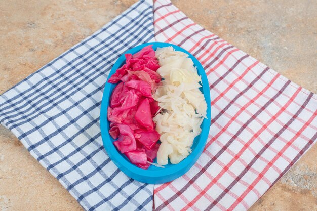 Chou fermenté rouge et blanc sur plaque bleue