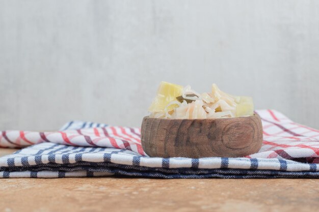 Chou mariné avec des tranches de légumes dans un bol en bois