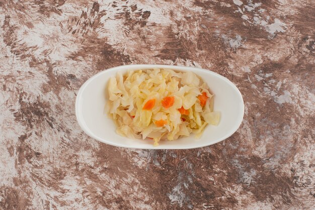 Choucroute maison dans un bol blanc sur table en bois.