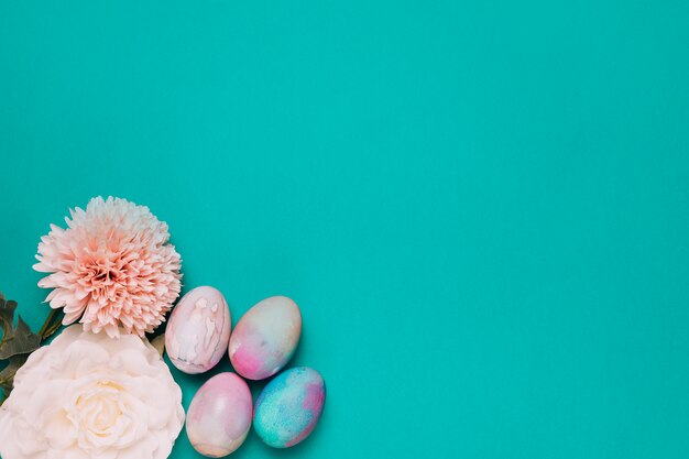 Chrysanthème; oeufs de pâques roses et peints au coin du fond vert