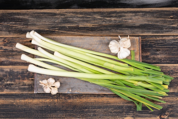 Ciboulette verte et blanche sur une planche à découper en bois