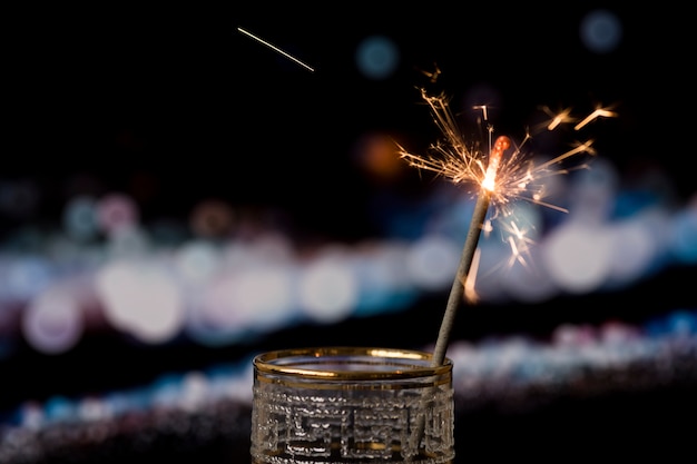 Photo gratuite cierge magique de noël sur fond sombre avec des lumières de bokeh