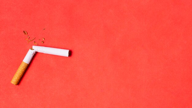 Cigarette cassée sur fond rouge