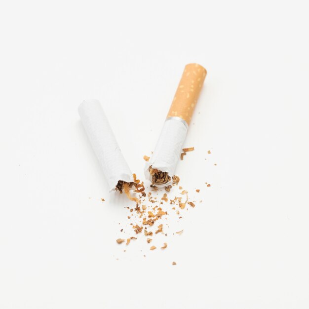 Cigarette cassée et tabac sur isolé sur fond blanc