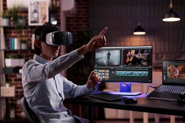 Cinéaste éditant un montage de film avec des lunettes de réalité virtuelle, utilisant un logiciel de production multimédia pour créer des séquences. Éditez la vidéo avec un étalonnage des couleurs et des effets visuels, en travaillant avec des lunettes vr.