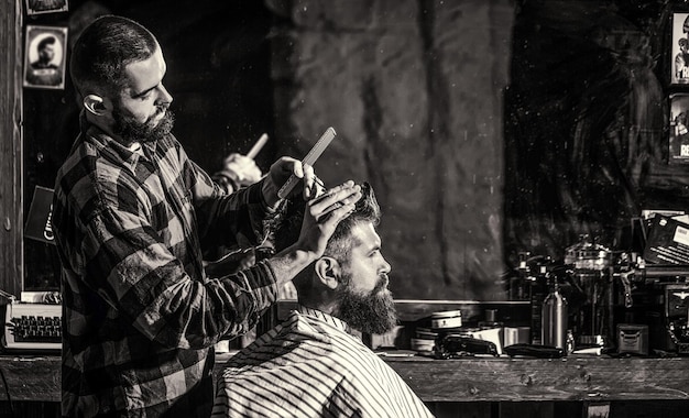 Ciseaux de coiffeur, salon de coiffure. salon de coiffure vintage, rasage. coiffeur homme. homme barbe en salon de coiffure. coiffeur servant le client au salon de coiffure, barbu.
