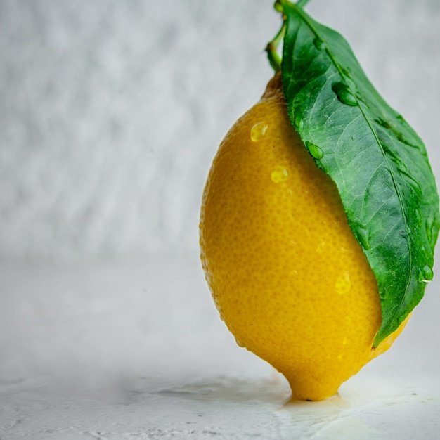 Photo gratuite citron avec sa vue latérale sur un fond texturé blanc