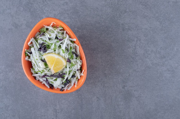 Citron tranché avec légumes râpés, sur la surface en marbre.