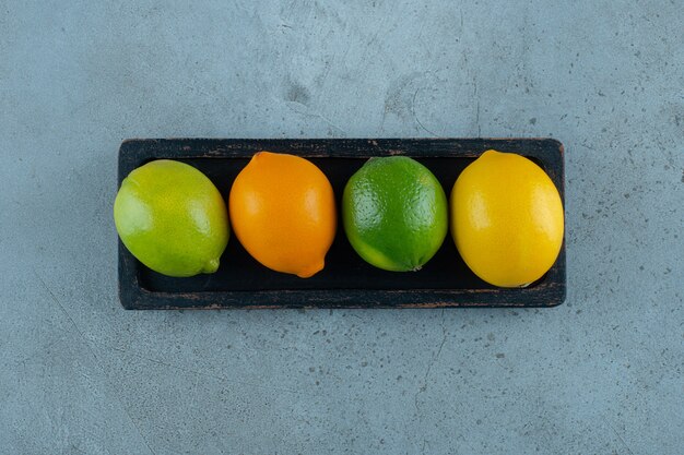 Citrons colorés sur une planche , sur le fond de marbre. photo de haute qualité