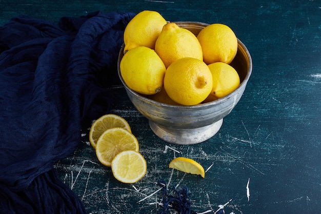 Citrons jaunes dans une tasse métallique.