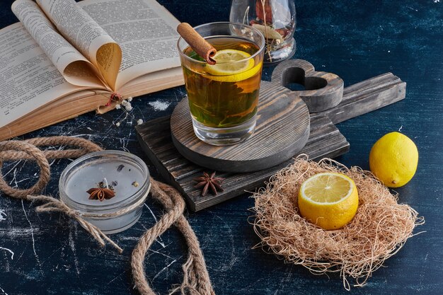 Citrons jaunes isolés sur une surface noire avec un verre de boisson.