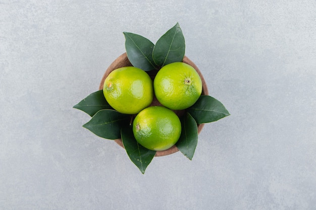 Citrons mûrs frais dans un bol en bois