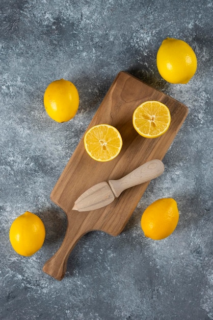 Citrons tranchés et entiers avec alésoir en bois.