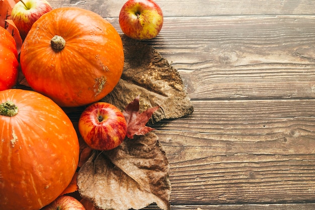 Citrouilles d'automne sur une table en bois avec des feuilles