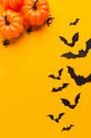 Photo gratuite citrouilles d'halloween et chauves-souris avec fond orange