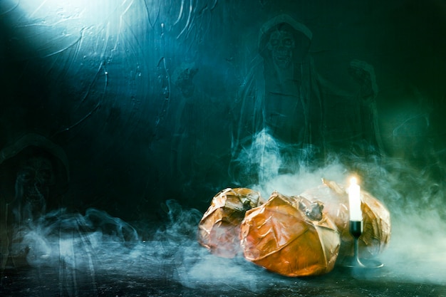 Citrouilles d&#39;Halloween faites à la main avec bougie allumée et fantôme et fumée