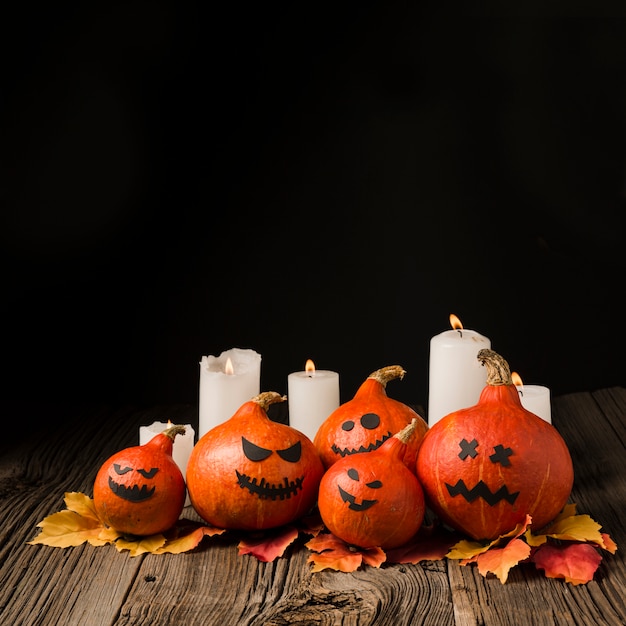 Photo gratuite citrouilles maléfiques décoratives avec des bougies et des feuilles