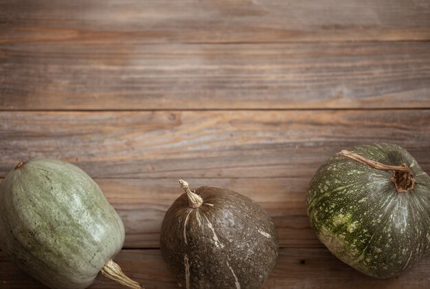 Citrouilles vertes sur fond de planches de bois vue de dessus se bouchent. Concept de récolte d'automne.