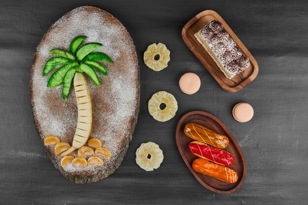 Éclairs avec composition de fruits et tranche de tiramisu.