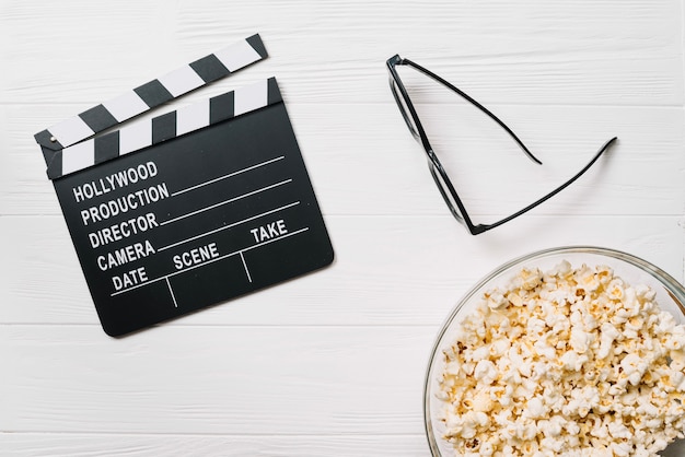 Clapperboard et verres avec du maïs soufflé