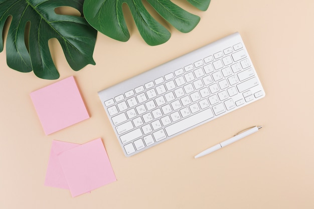 Clavier avec des autocollants et un stylo sur une table jaune