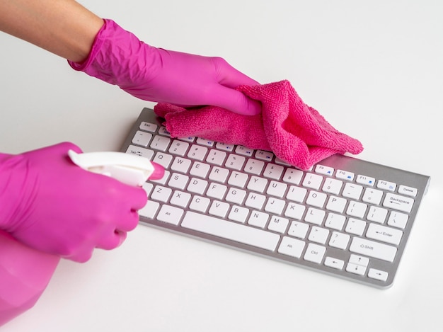 Clavier désinfecté par une personne avec des gants chirurgicaux