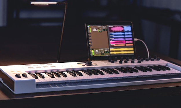 Photo gratuite clavier musical et tablette dans une production musicale dans une pièce sombre