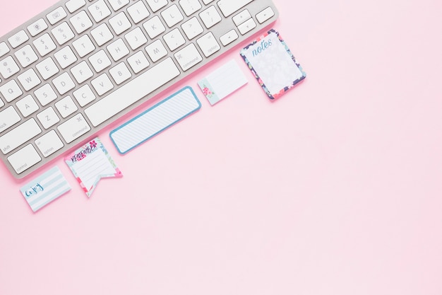 Photo gratuite clavier avec des notes mignonnes sur le bureau