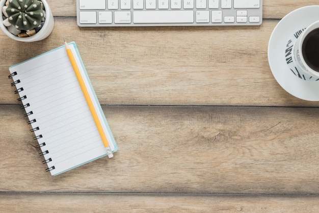 Clavier d'ordinateur portable et une tasse de café sur une table en bois