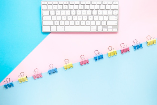 Photo gratuite clavier et papier avec des clips colorés sur le bureau