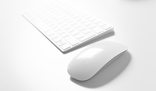 Clavier et souris d'ordinateur sur le dessus du bureau blanc