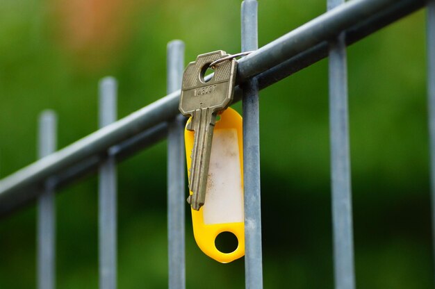 Une clé perdue avec un badge jaune sur une clôture.