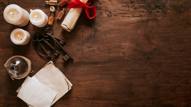 Photo gratuite clés et parchemin près des bougies