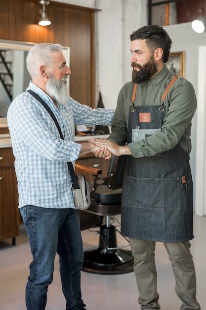 Client et coiffeur se saluant au salon de coiffure