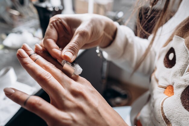 Client essayant des tailles de bague à portée de main dans un atelier de bijouterie