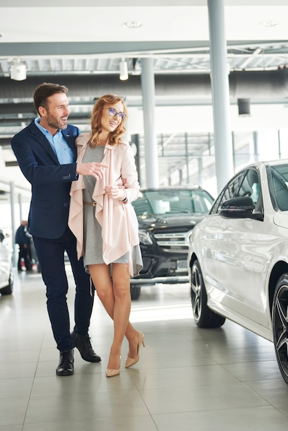 Client masculin excité avec sa femme dans une salle d'exposition