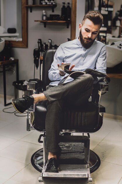 Client regardant un magazine dans un salon de coiffure