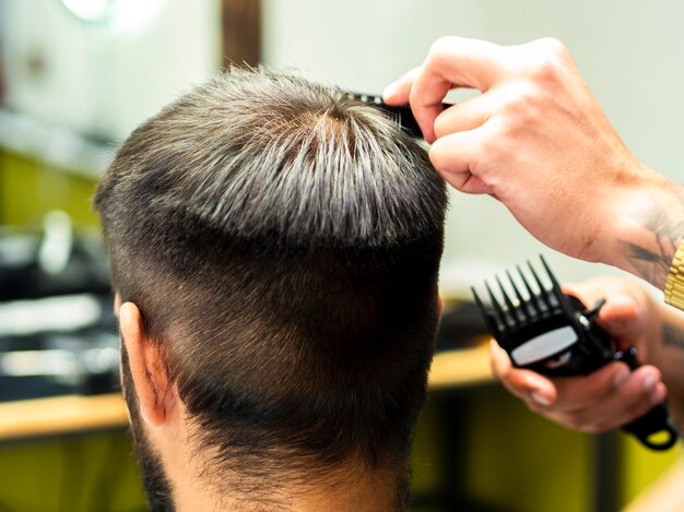 Une cliente se faisant couper les cheveux par derrière