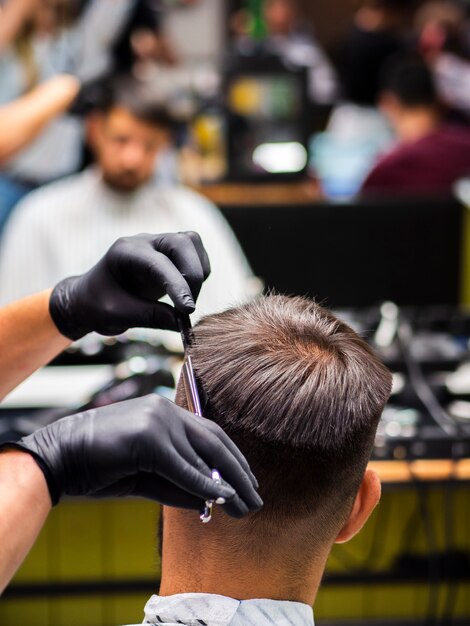 Une cliente se faisant couper les cheveux par derrière