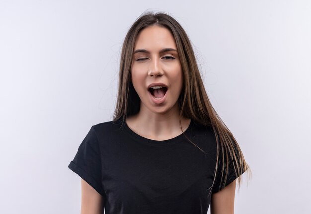 Clignoté jeune fille caucasienne portant un t-shirt noir sur un mur blanc isolé